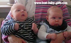 twins: baby boy and baby girl sitting on someone's lap