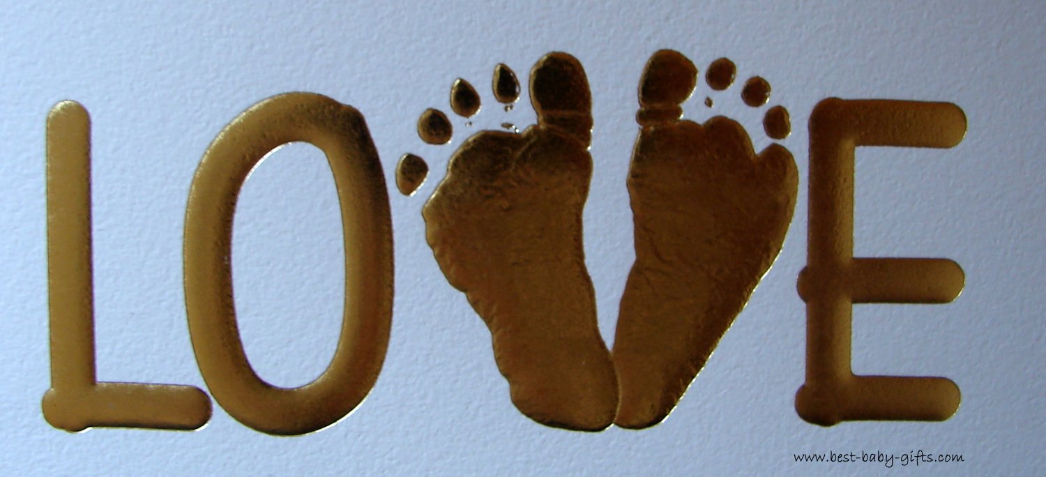 LOVE written in big, golden letters. The V is formed by two baby feet. White background.