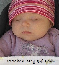 a baby girl with a pink hat sleeping safe and sound