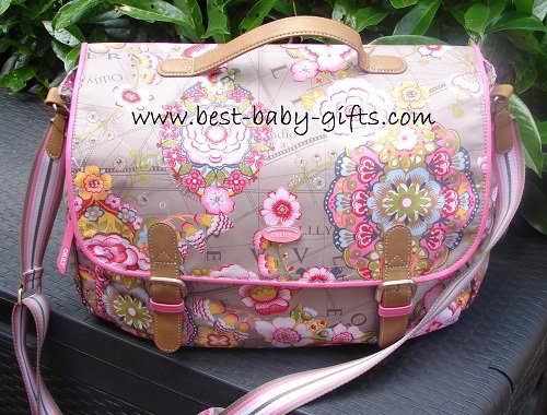 a light-brown messenger diaper bag with a big, prominent pink and yellow boho / flower design