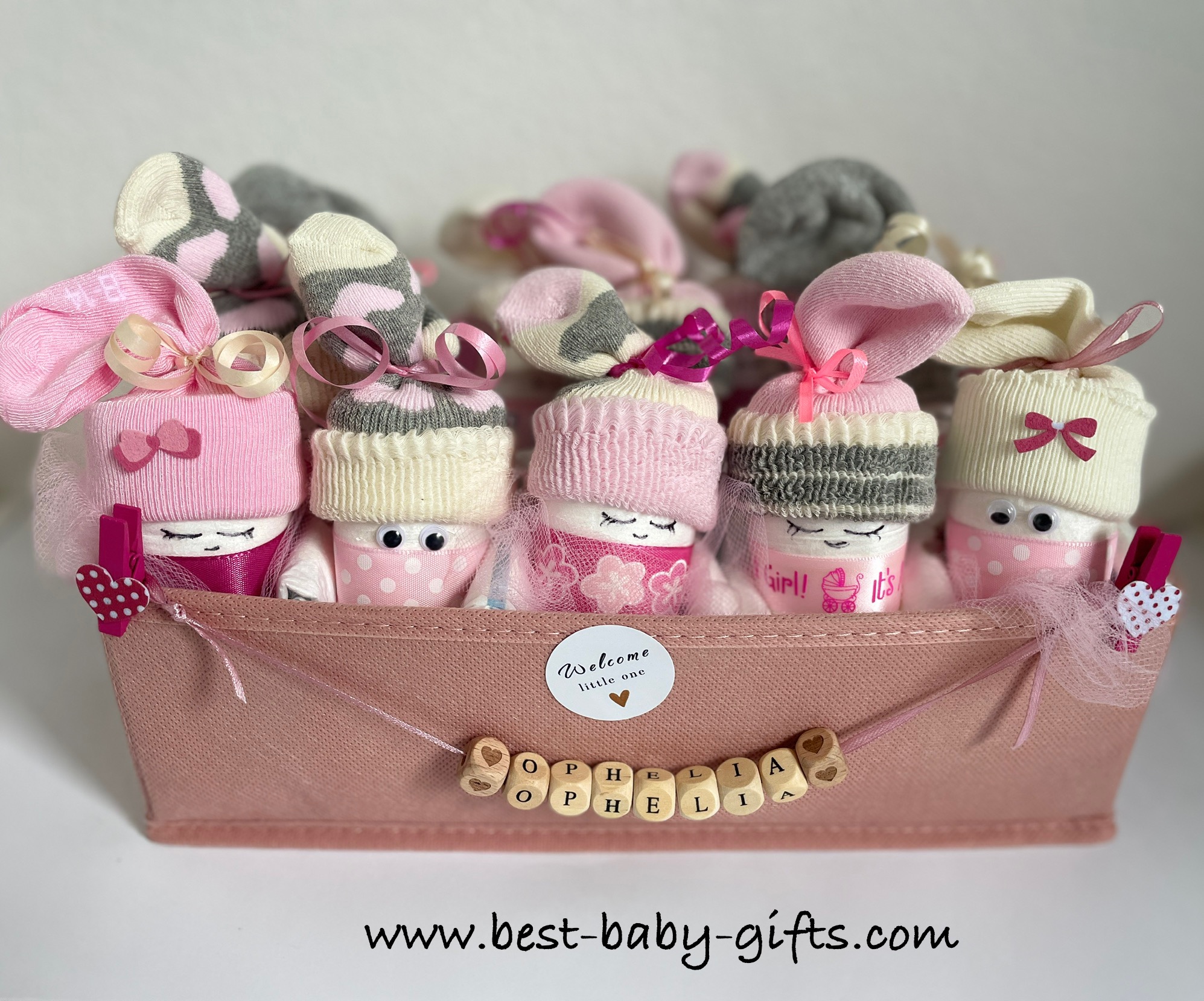 lots of diaper babies / sock babies in a pink storage box