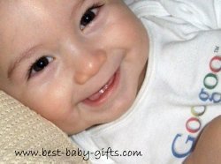 happy baby boy smiling brightly wearing a onesie saying "googoo"