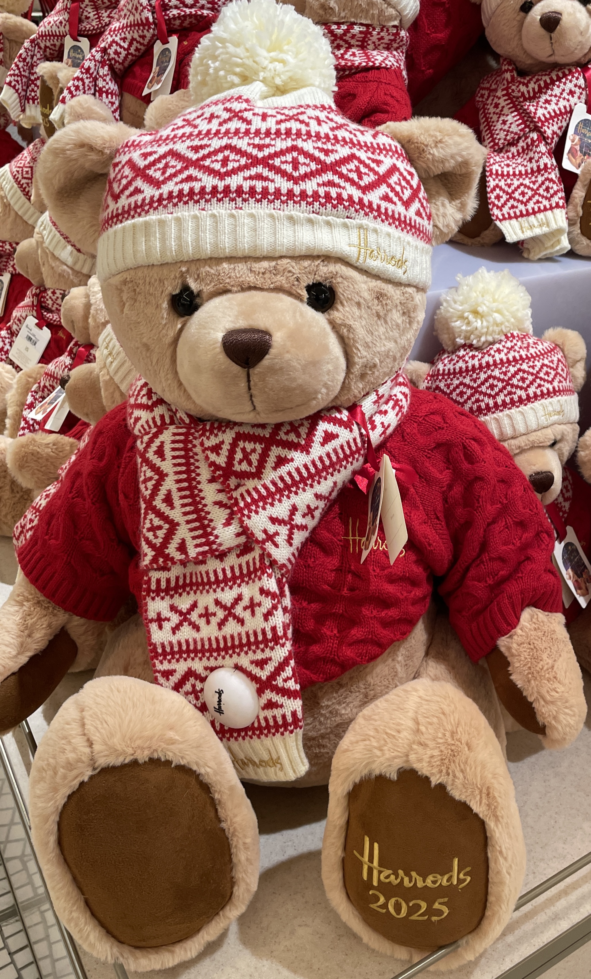 The Harrods Christmas Bear 2025 wearing a matching Christmas hat, scarf and sweater