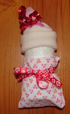 rolled diaper, fixed washcloth and baby sock as hat, sock fixed with a ribbon