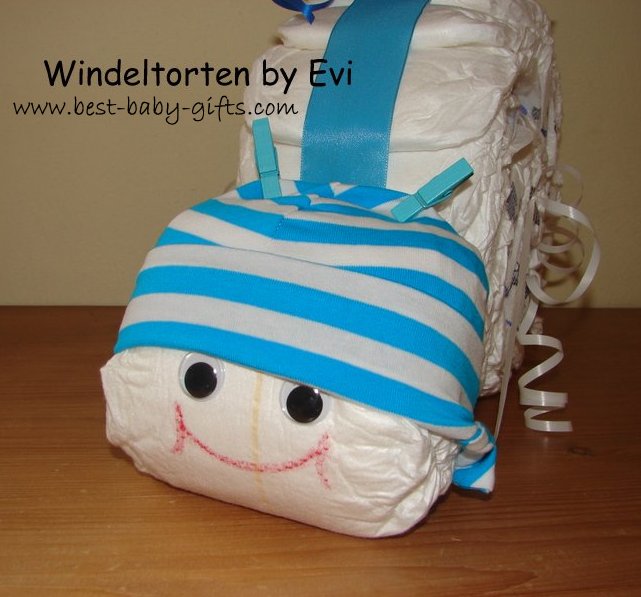 head of a diaper snail with a blue and white striped baby hat and two little blue clothes pegs as feelers