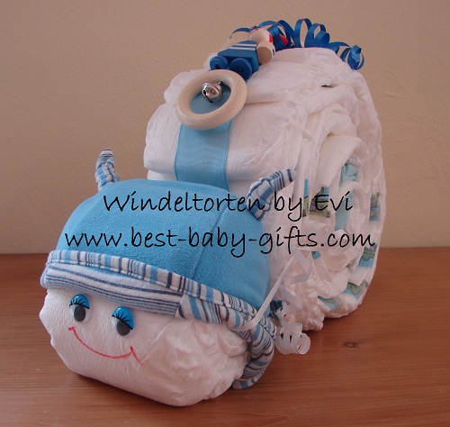 a diaper snail with blue ribbon, a blue hat and a blue toy on top, it has friendly blue wobbly eyes