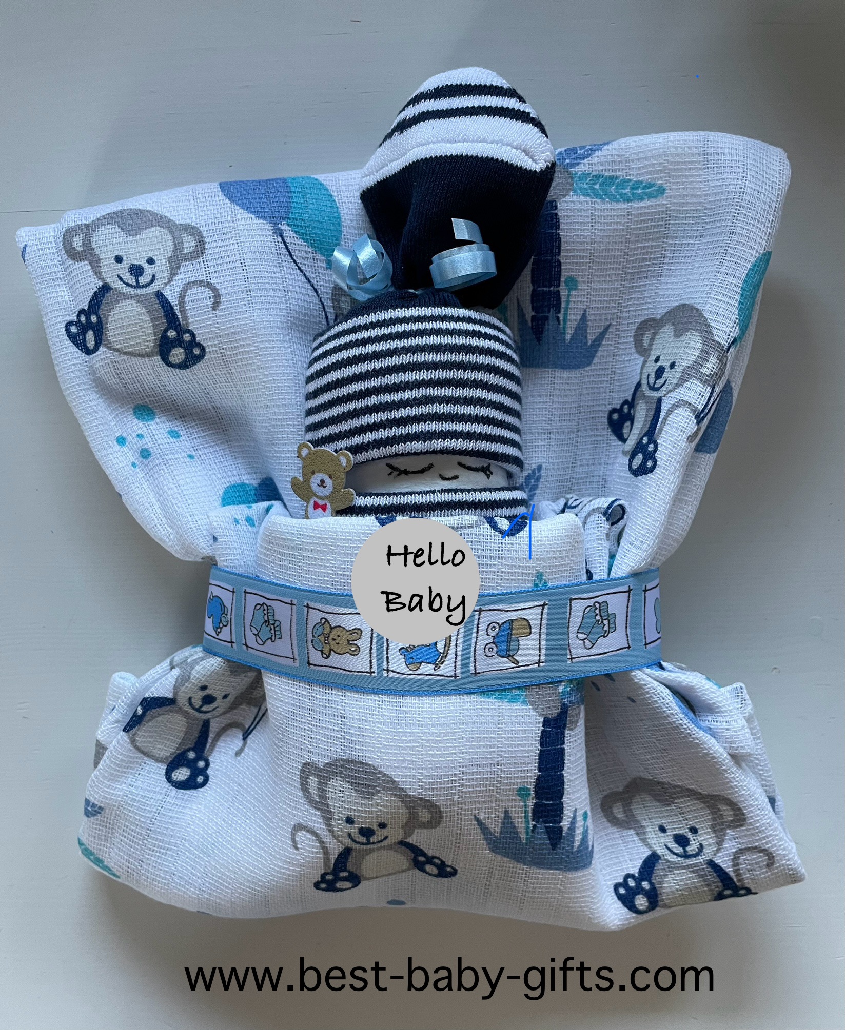 diaper baby for baby boy (in white / blue colors), wrapped in a burp cloth