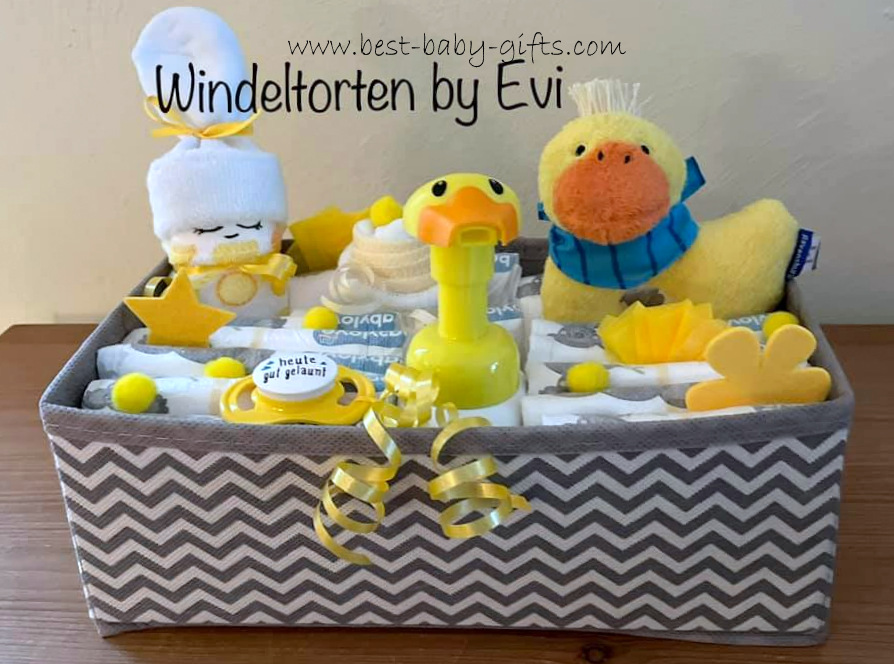 a gray basket filled with diapers, a duck baby toy, a soap dispenser in duck shape, a diaper baby and yellow accessories