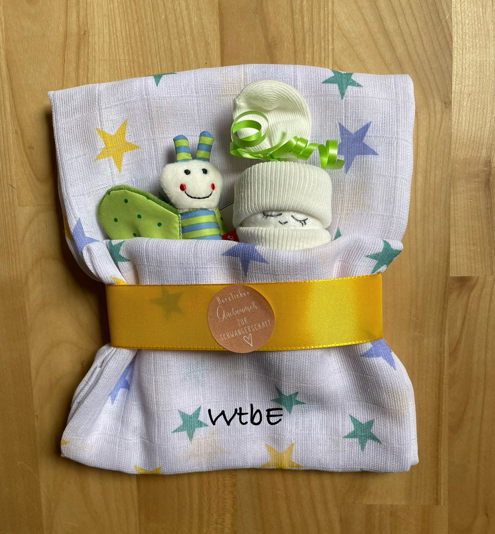 Windelbaby und ein Rassel Schmetterling im Tuch, Farben grün / gelb