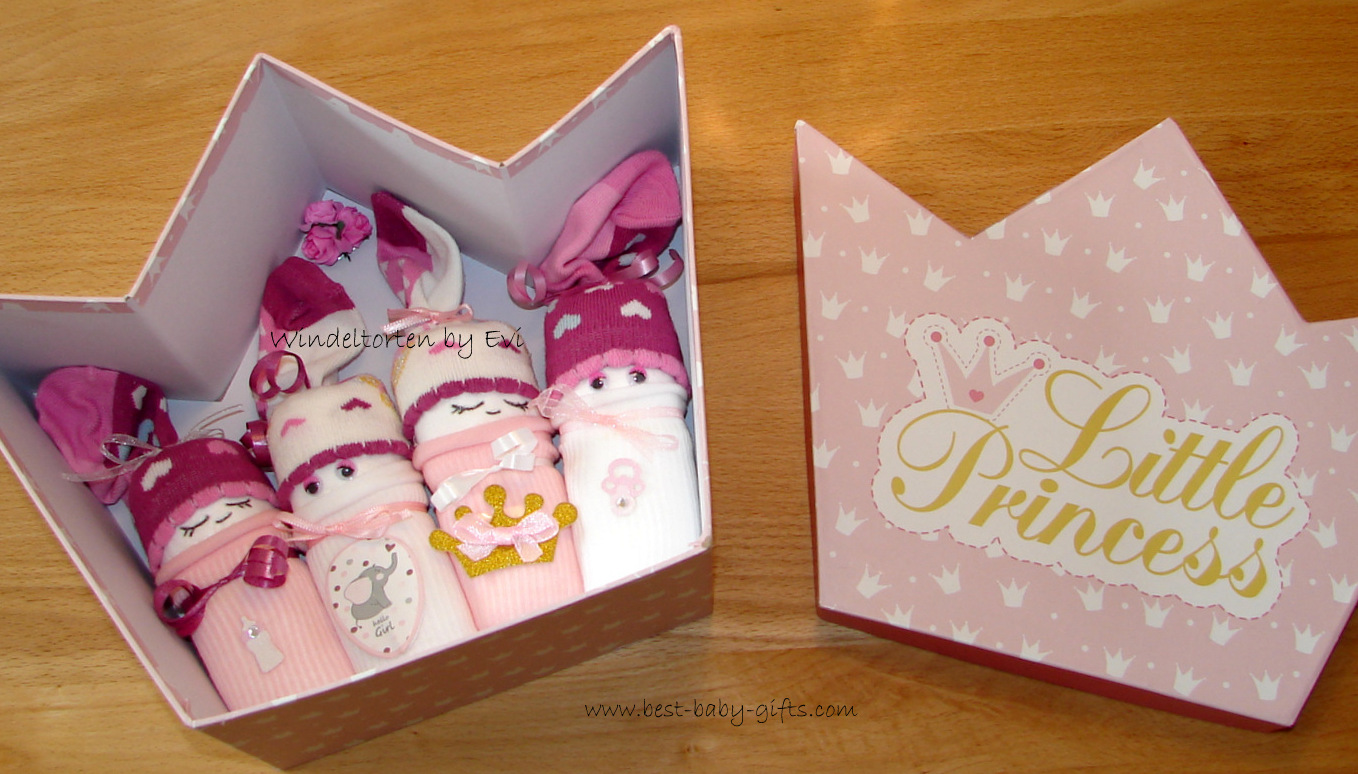 4 pink and white girl diaper babies placed in a crown shaped box