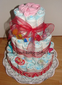 3 tiers diaper cake in pink and red, personalized with large wooden letters "Margarethe"