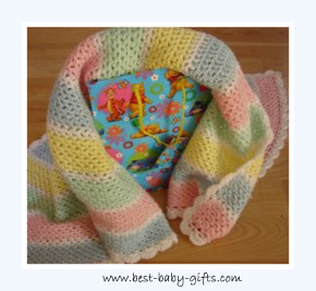 a gift bag covered with a crocheted baby blanket in pastel colors