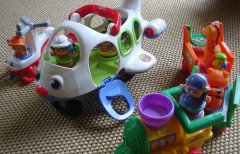 various Little People toys lined up on the floor