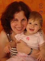 a mother holding up her baby girl (about 1 year old), both are looking very happy