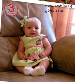 a cute baby girl sitting on a sofa, 3 months sticker at top left