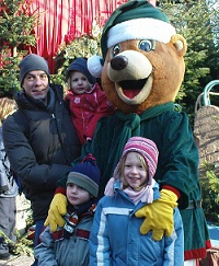 a father, 3 kids and a large Teddy Bear Character  in winter time