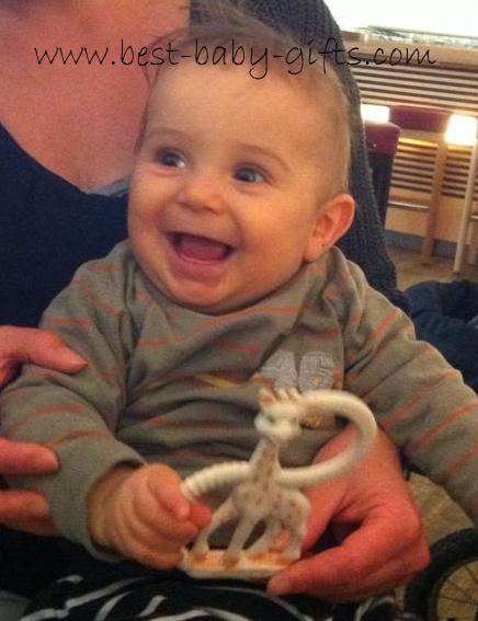 smiling baby boy with Sophie in his hands