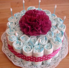 plain, one tier diaper cake with a dark pink napkin flower on top