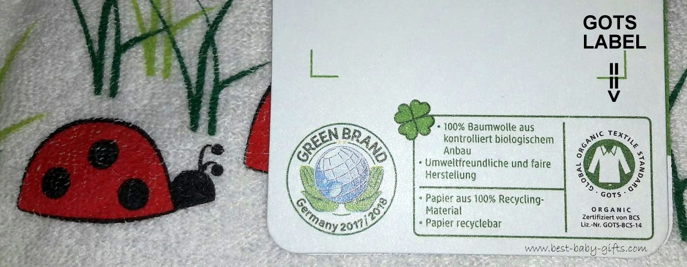 photo of a GOTS label that's attached to a baby bib that has a ladybird design