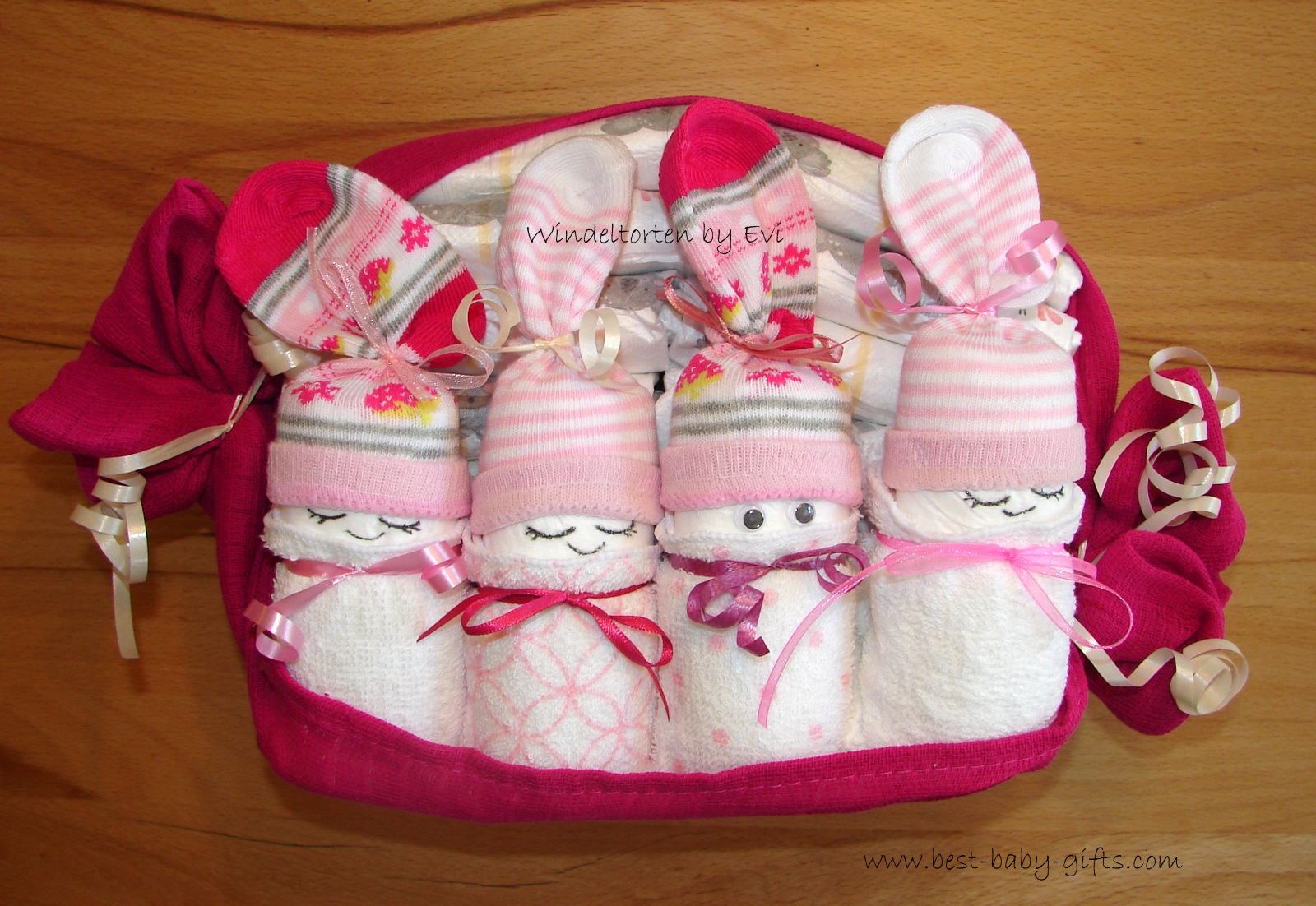 4 organic diaper babies for a baby girl placed in a pink organic burp cloth