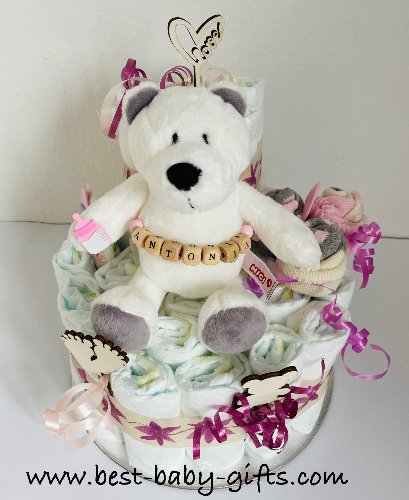 polar diaper cake for girl - personalized with wooden letters "Antonia" and decorated with lots of curly ribbons in pink shades