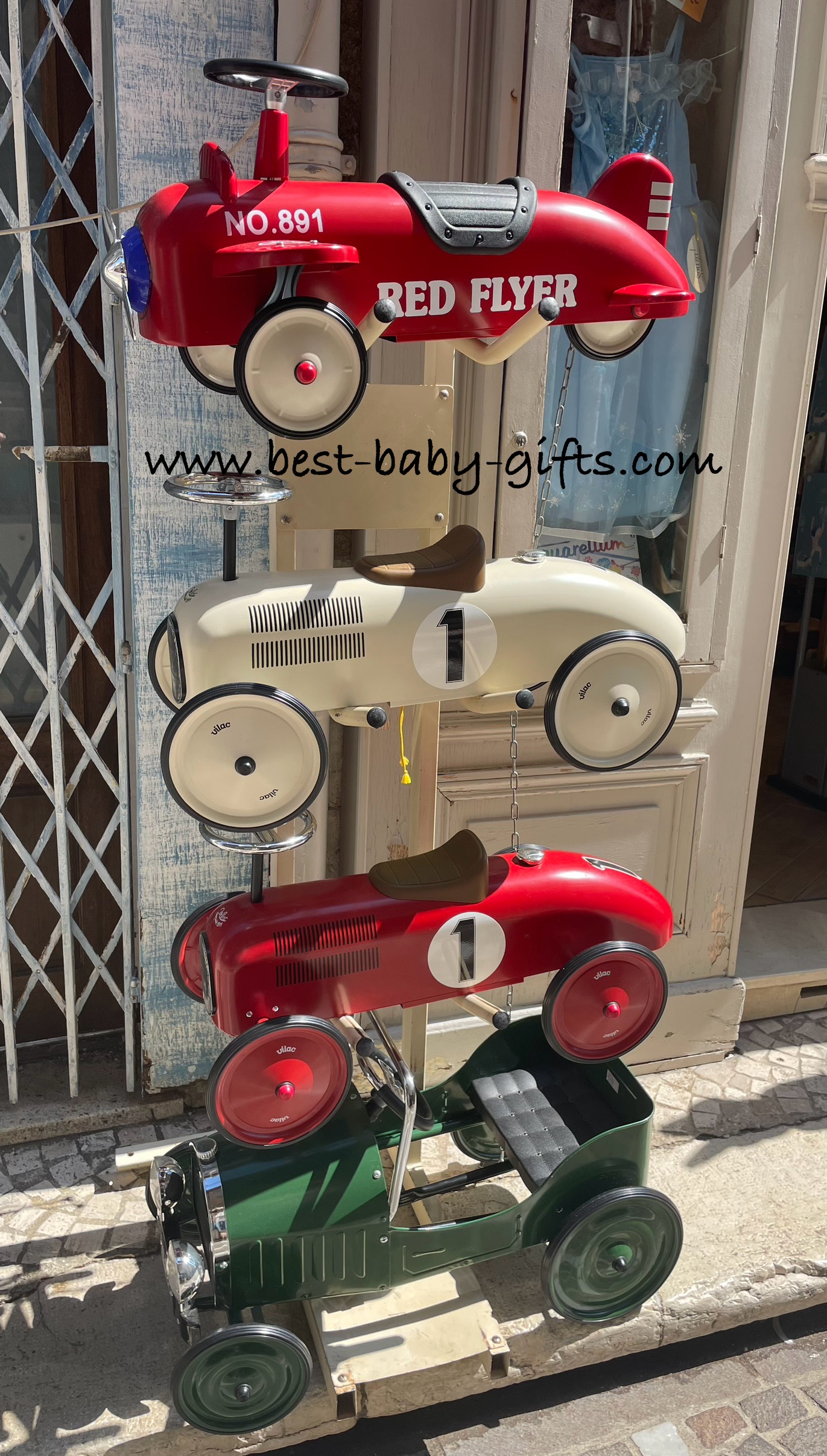 4 vintage ride on cars / planes displayed in front of a toy shop