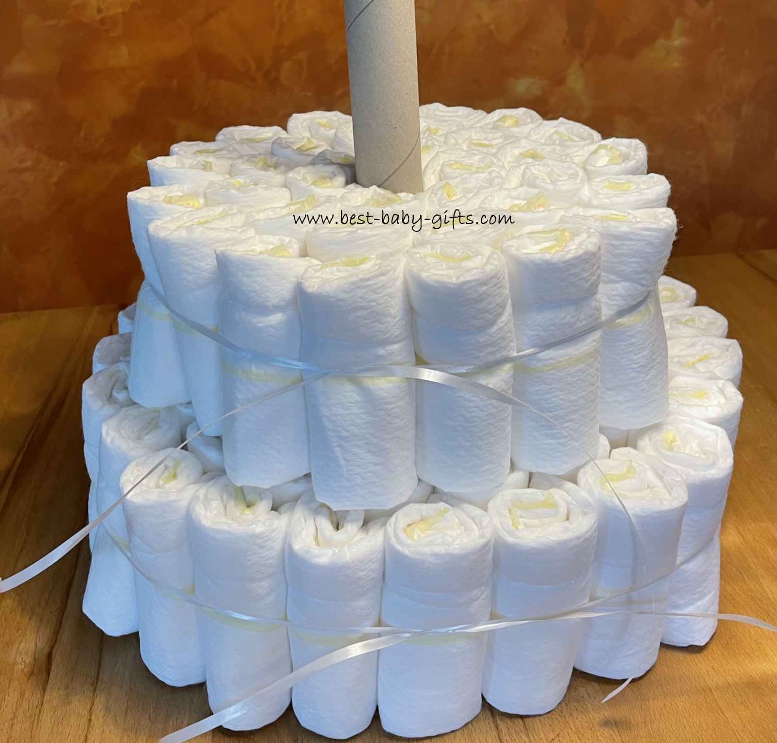 2 tiers of a diaper cake, rolled diapers and an empty kitchen towel roll in the middle.
