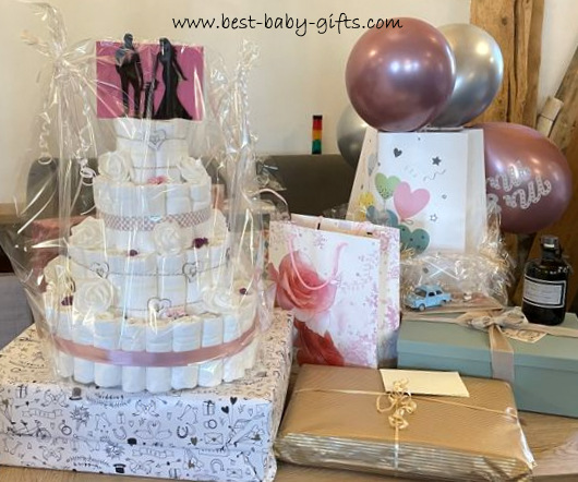 lots of wedding gifts showcased at a table with the wedding diaper cake being the eye catcher