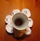 von oben: aufgestellte Küchentuchrolle und 6 gerollte Windeln außen herum