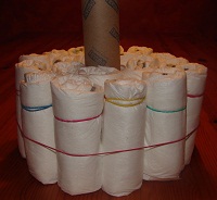 aufgestelle Küchenrolle und 2 Schichten aufgerollte Windeln außen herum, fixiert mit Gummi