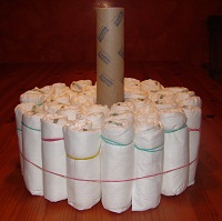 aufgestelle Küchenrolle und 3 Schichten aufgerollte Windeln außen herum, fixiert mit Gummi